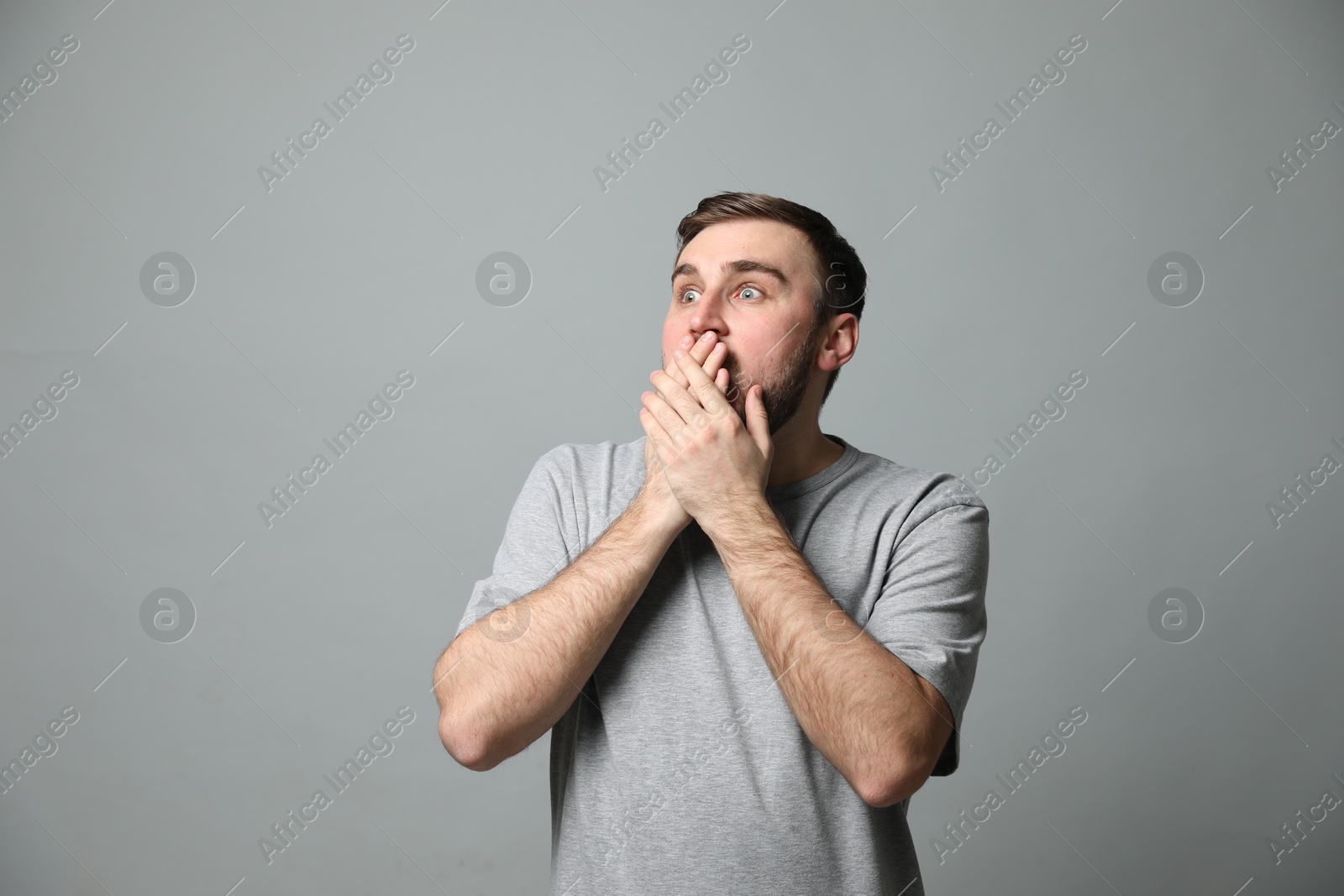 Photo of Young man feeling fear on grey background