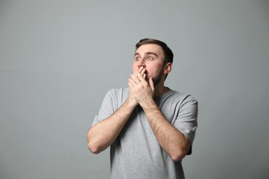 Photo of Young man feeling fear on grey background