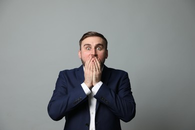 Photo of Young businessman feeling fear on grey background