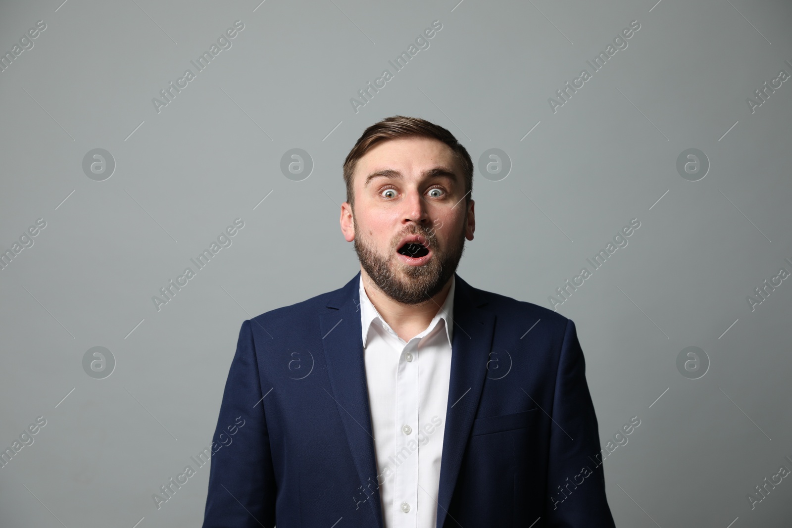 Photo of Young businessman feeling fear on grey background