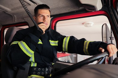 Firefighter using radio set while driving fire truck