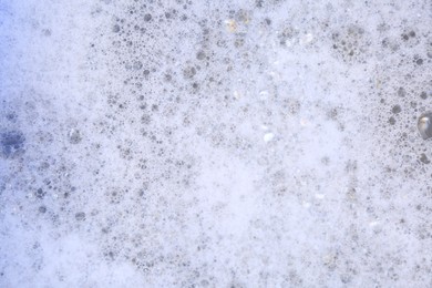 Photo of Detergent foam as background, top view. Hand washing laundry