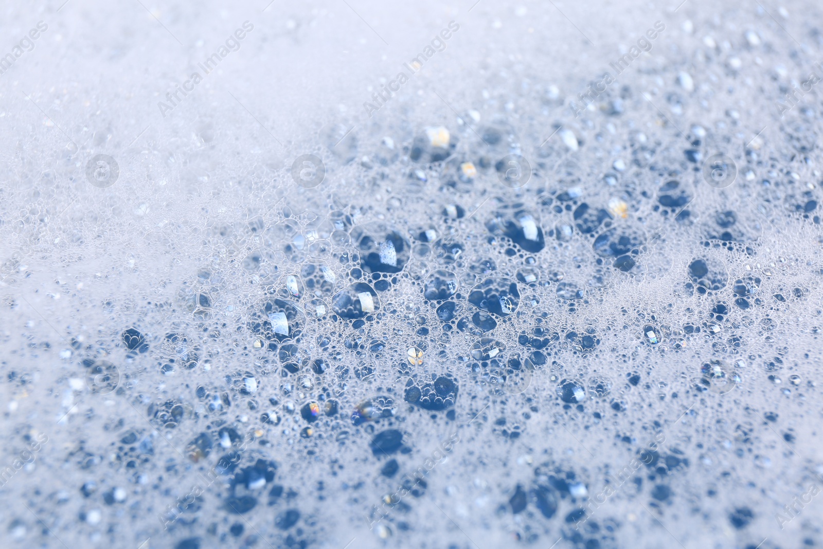 Photo of Detergent foam as background, closeup. Hand washing laundry