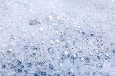 Photo of Detergent foam as background, closeup. Hand washing laundry