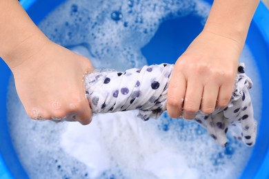 Photo of Woman wringing garment over basin, closeup. Hand washing laundry