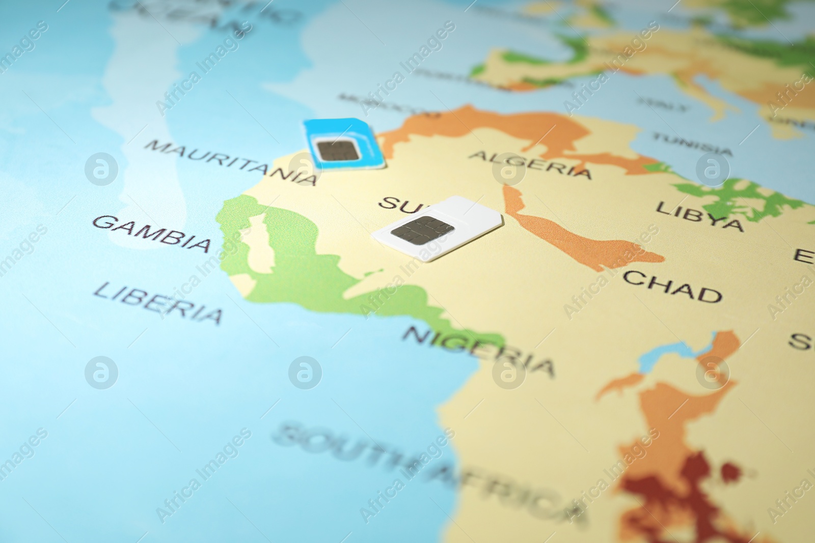 Photo of Modern SIM cards on world map, closeup