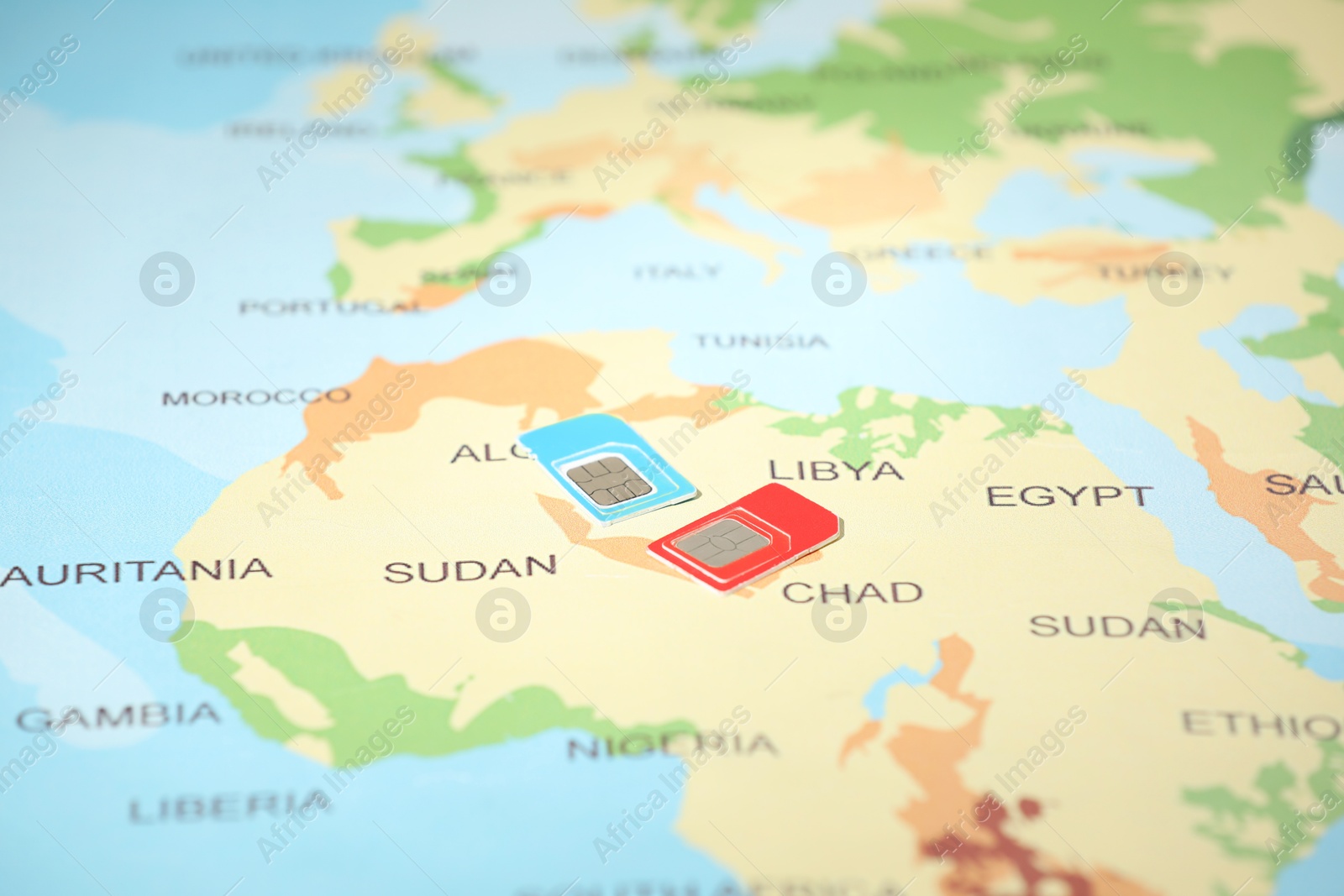 Photo of Modern SIM cards on world map, closeup