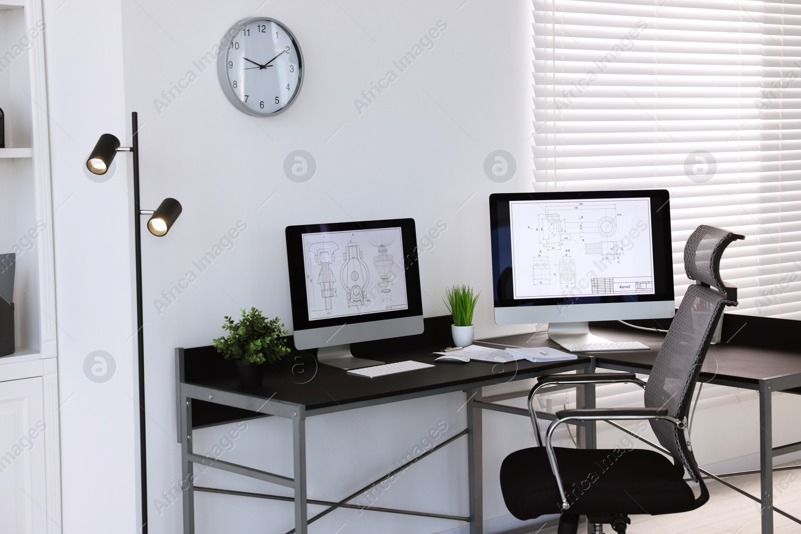 Photo of Modern computers with digital engineering drawing at table in office