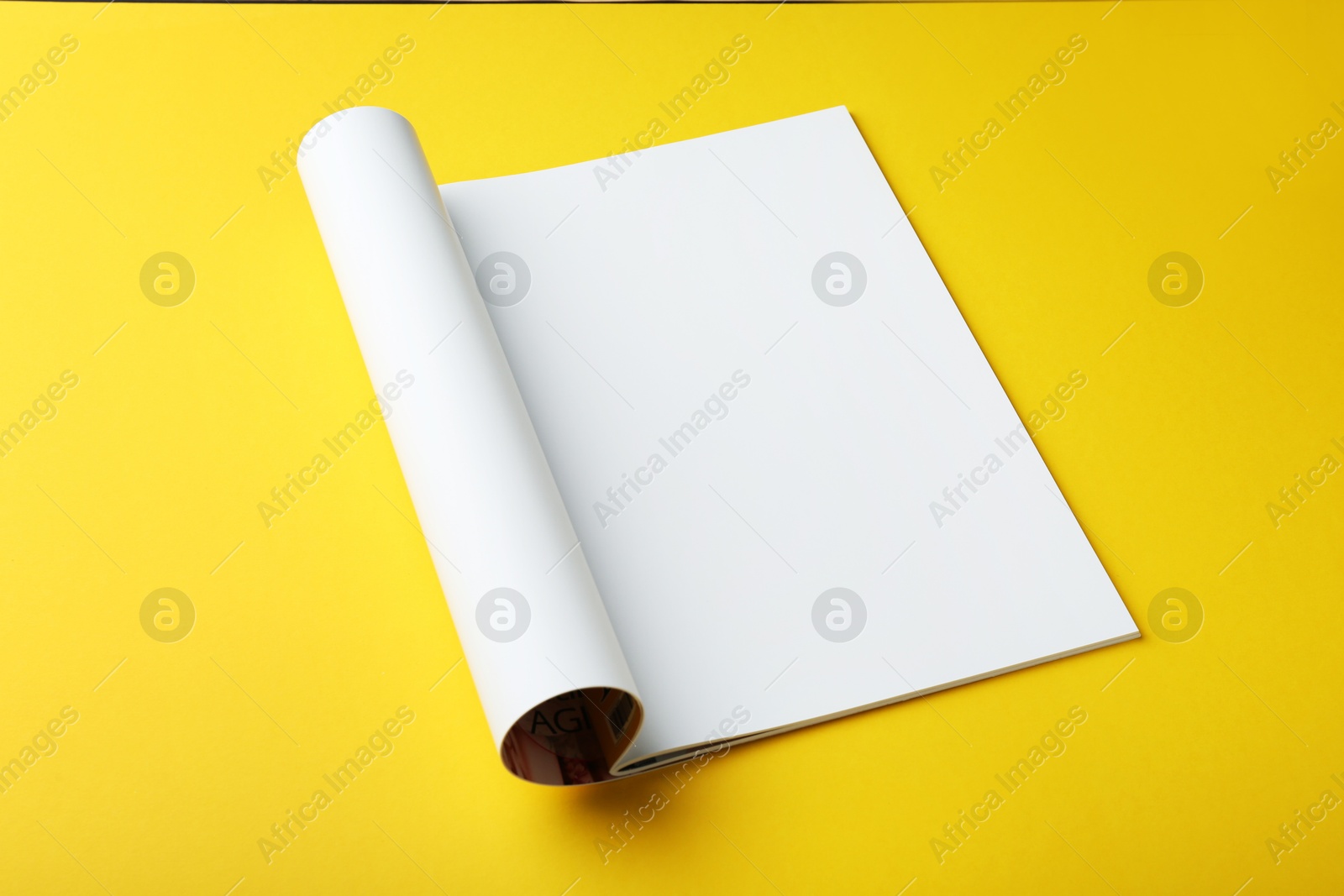 Photo of Open magazine with blank page on yellow background. Mockup for design