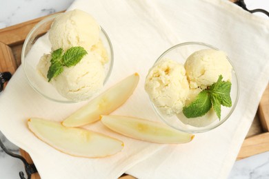 Photo of Scoops of melon sorbet with mint in glass dessert bowls and fresh fruit on table, top view