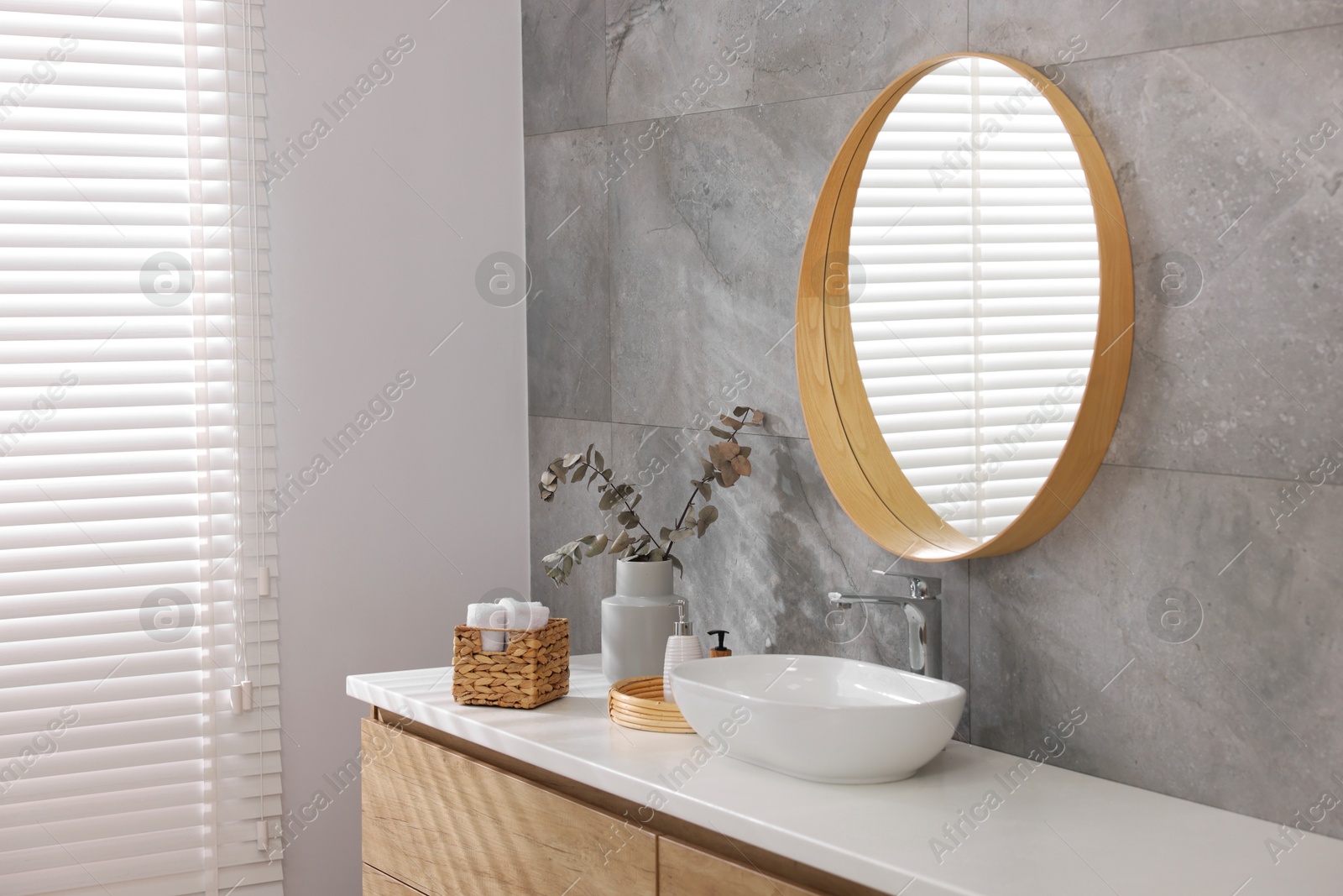 Photo of Bath accessories, eucalyptus branches, sink and mirror in bathroom