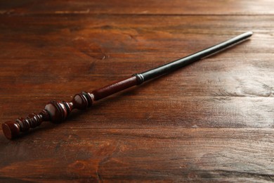 Photo of One old magic wand on wooden table, closeup