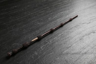 Photo of One old magic wand on black table, closeup