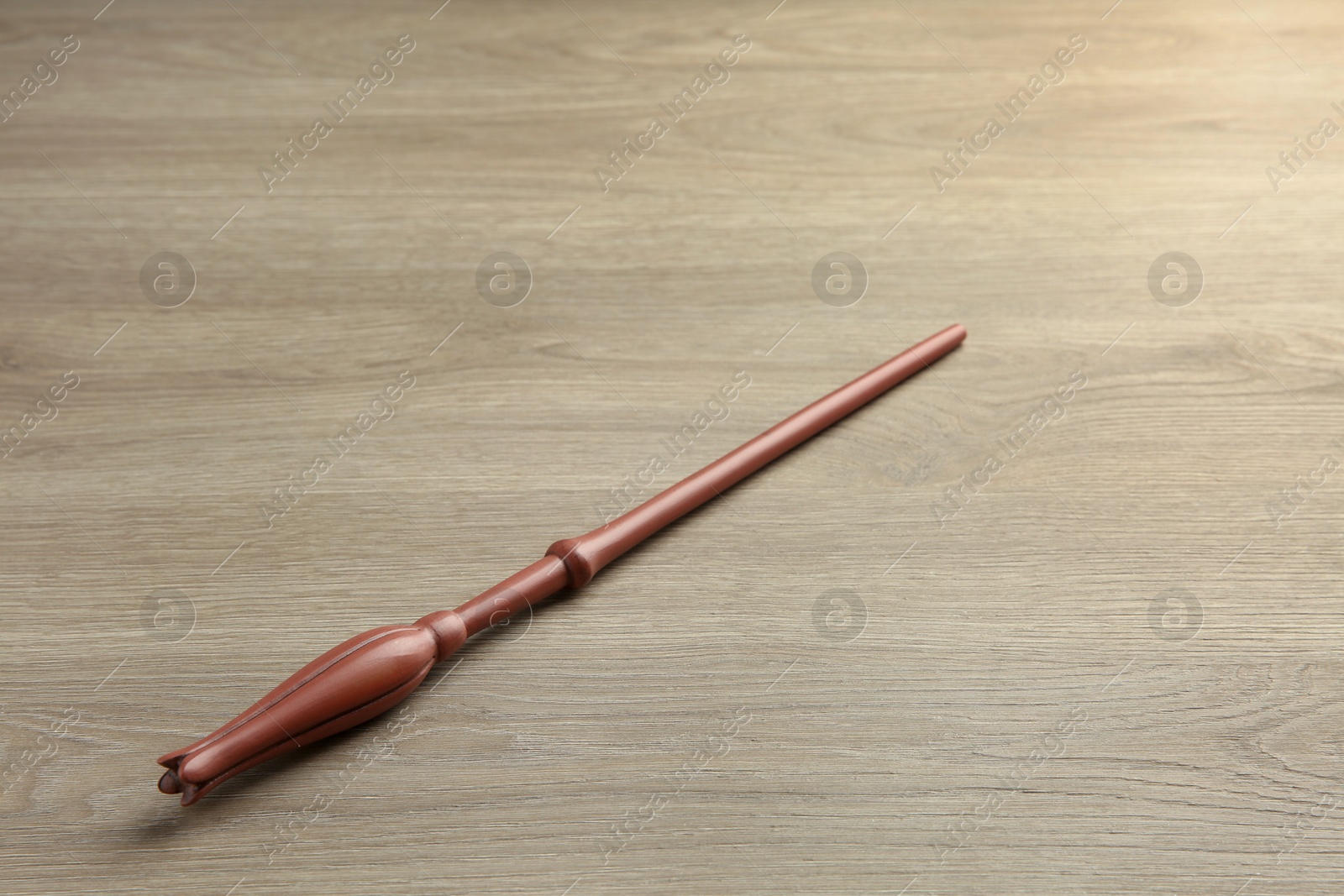 Photo of One magic wand on light wooden table