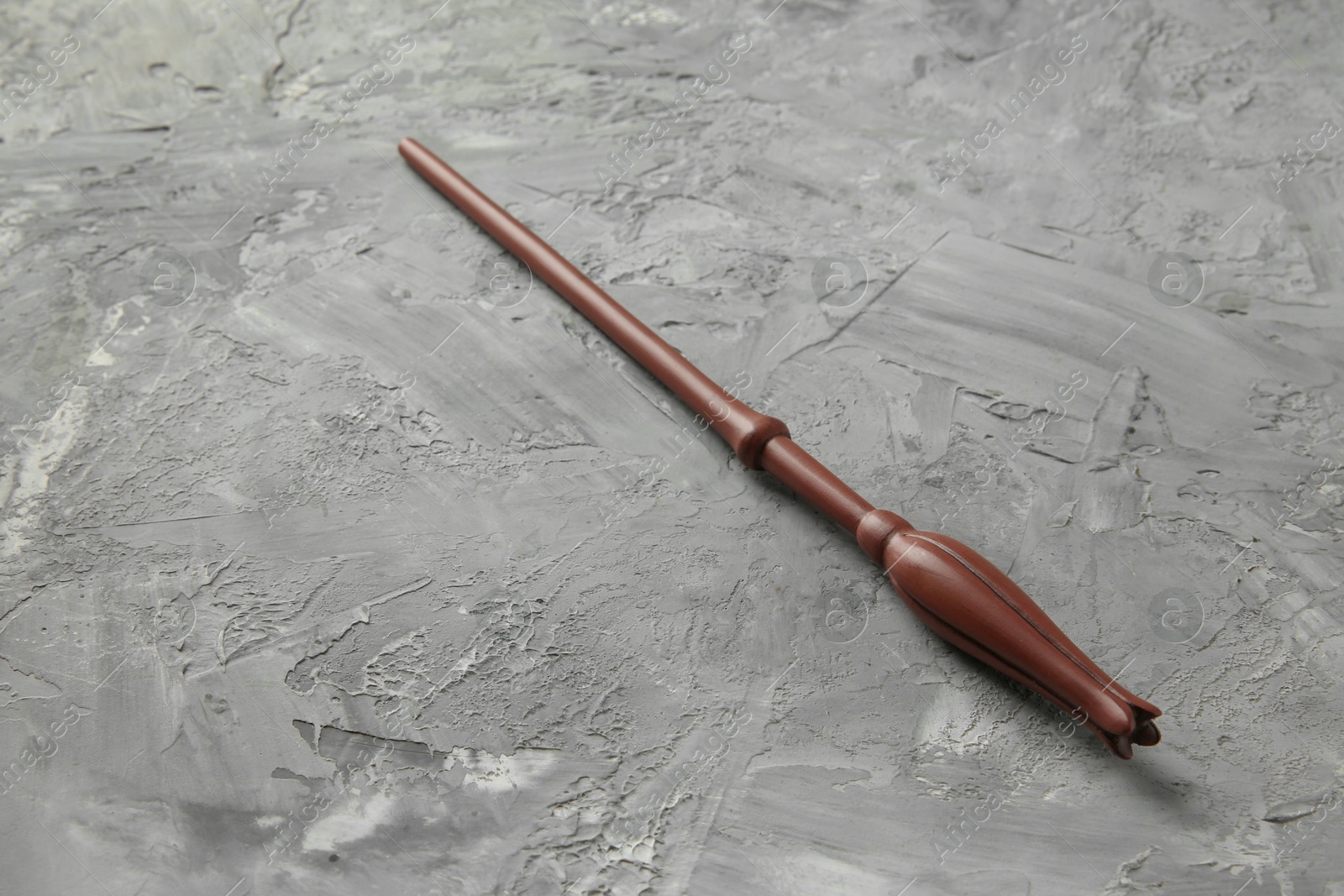 Photo of One magic wand on grey textured table