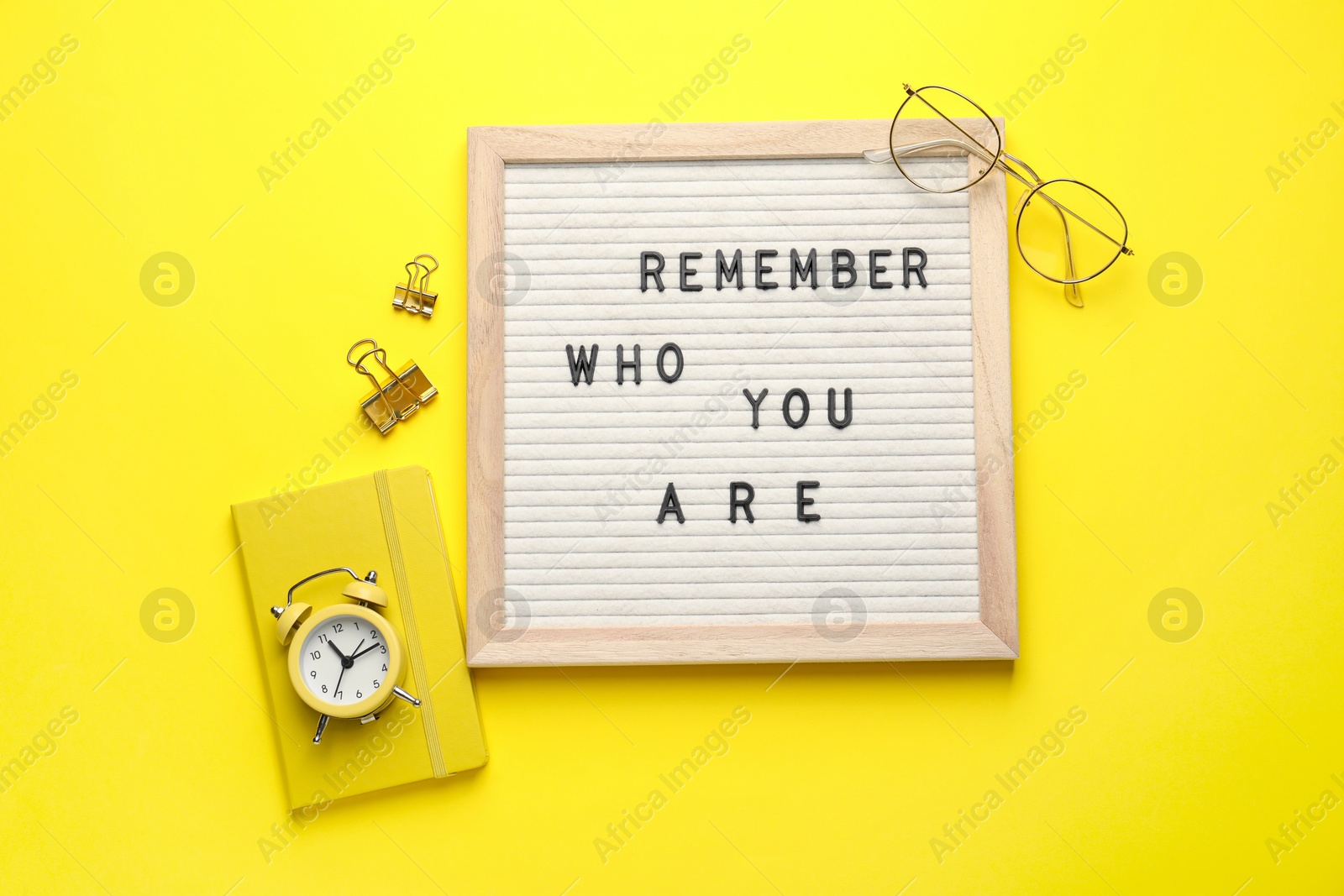 Photo of Flat lay composition of letter board with phrase Remember Who You Are on yellow background