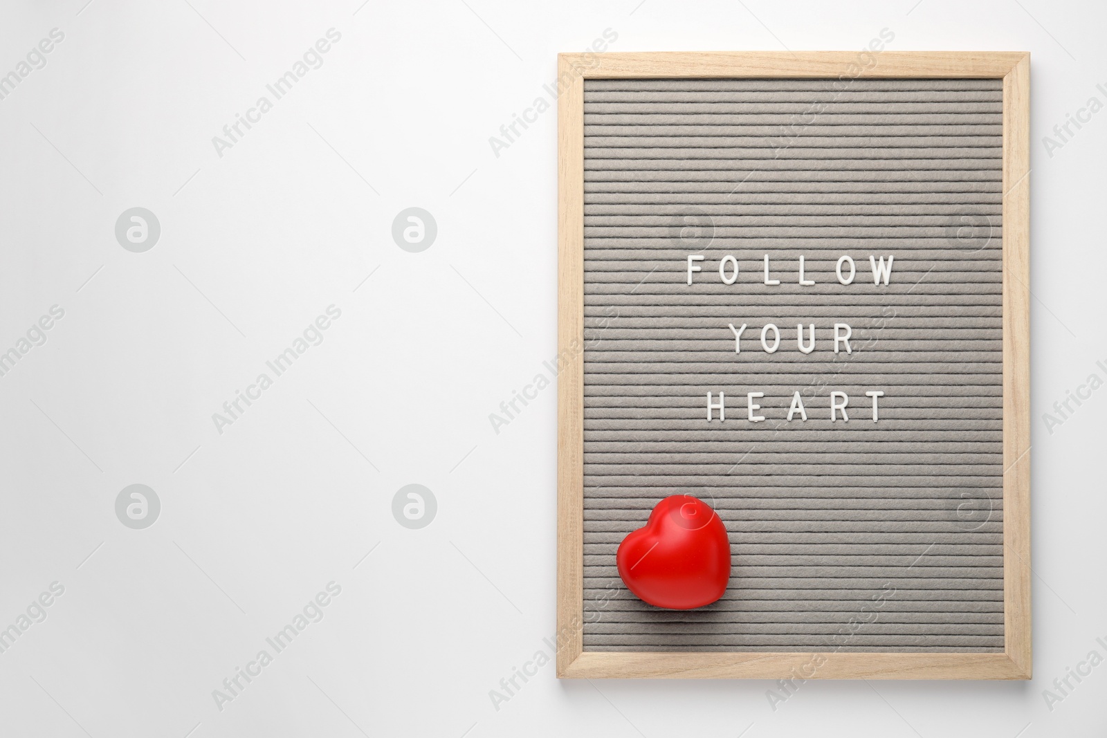 Photo of Letter board with phrase Follow Your Heart and decorative figure on white background, top view. Space for text