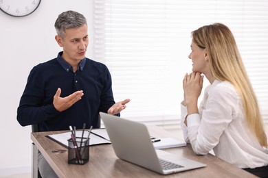 Banker working with client at wooden table in office