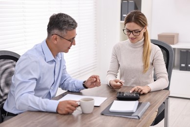 Banker working with client at table in office