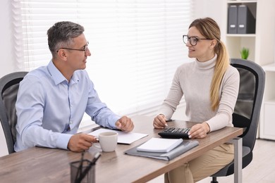 Banker working with client at table in office