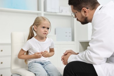 Doctor consulting little girl with stomach pain in hospital