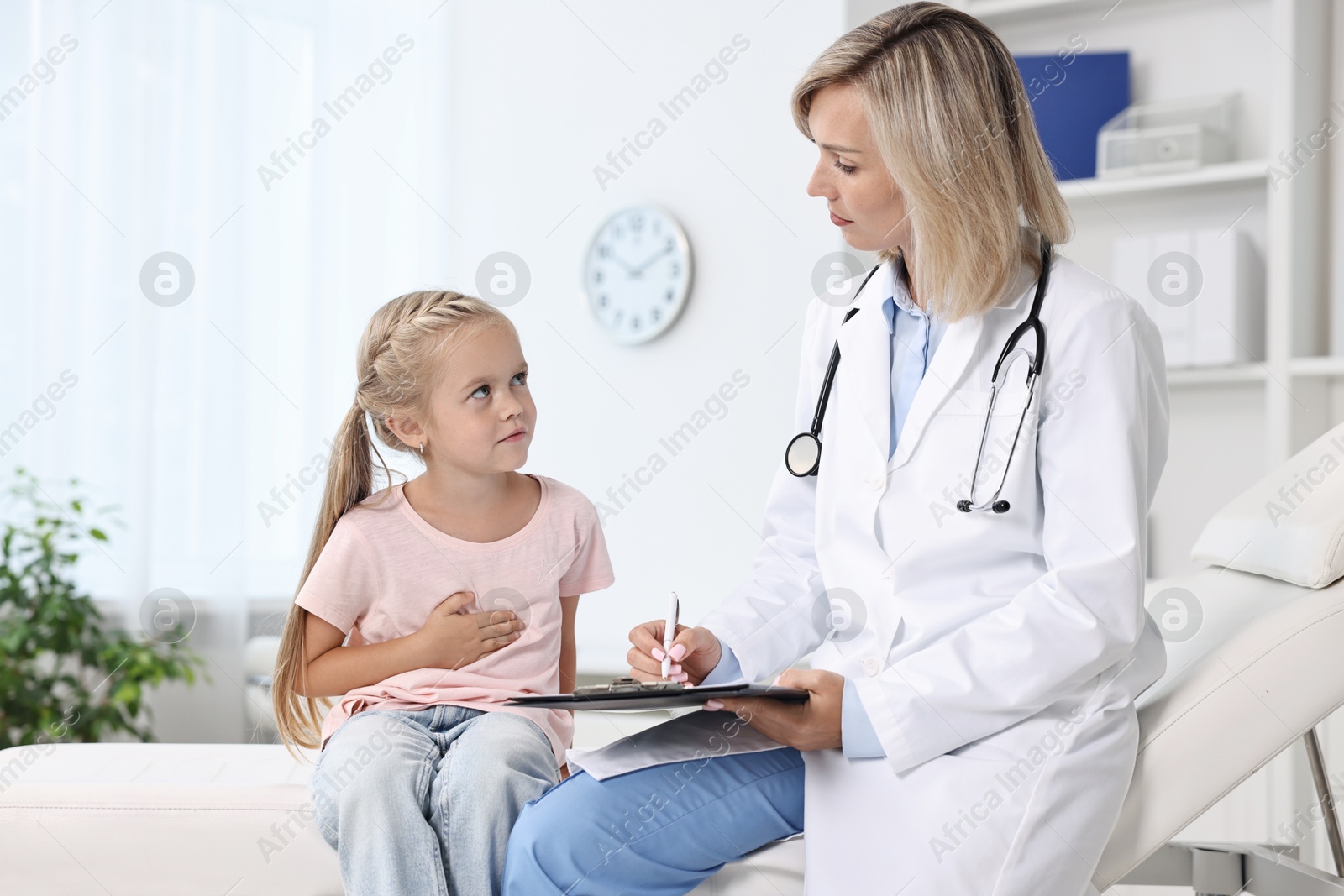 Photo of Doctor consulting little girl with stomach pain in hospital