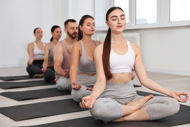 Group of people meditating on mats in yoga class