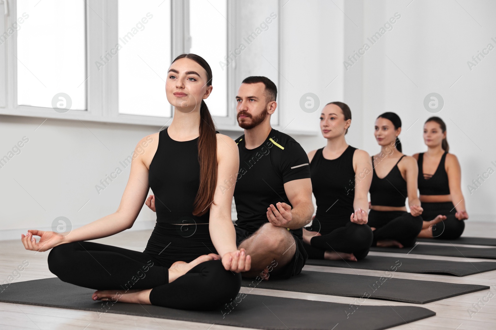 Photo of Group of people meditating on mats in yoga class