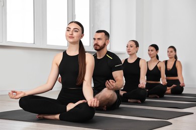 Group of people meditating on mats in yoga class