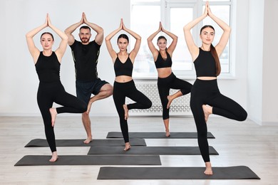 Group of people practicing yoga on mats in class