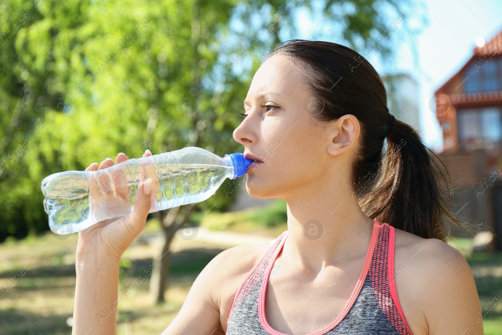 Photo of Woman drinking tasty soda water outdoors on sunny day