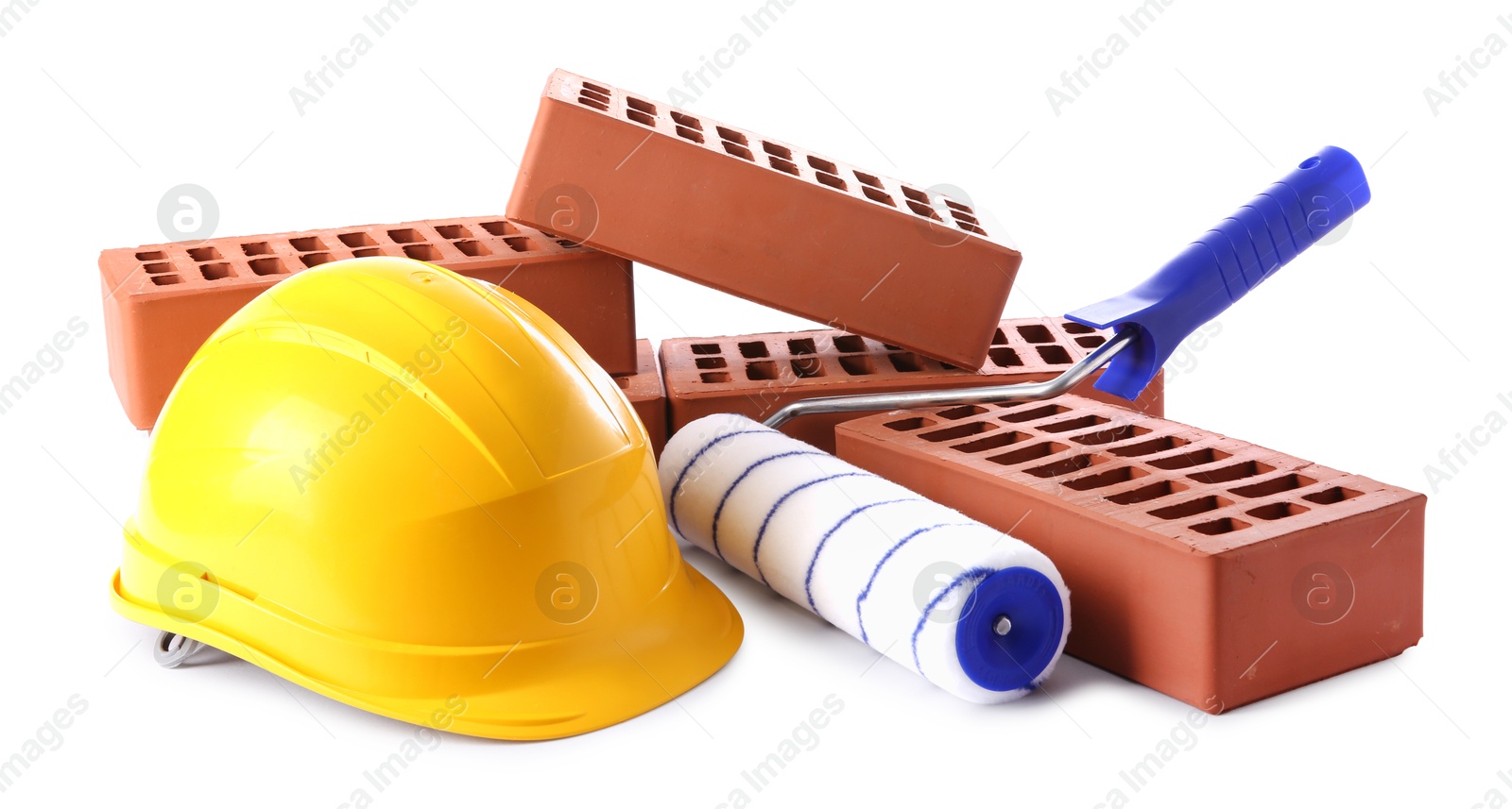 Photo of Yellow hard hat, red bricks and roller isolated on white. Building material and construction tools