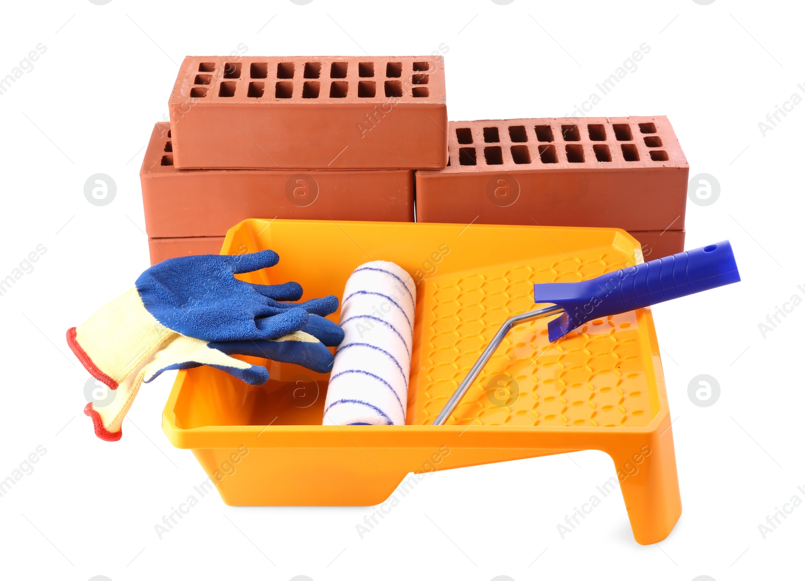 Photo of Red bricks, roller, gloves and tray isolated on white. Building material and construction tool