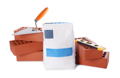 Cement powder in bag, trowel, red bricks and building level isolated on white