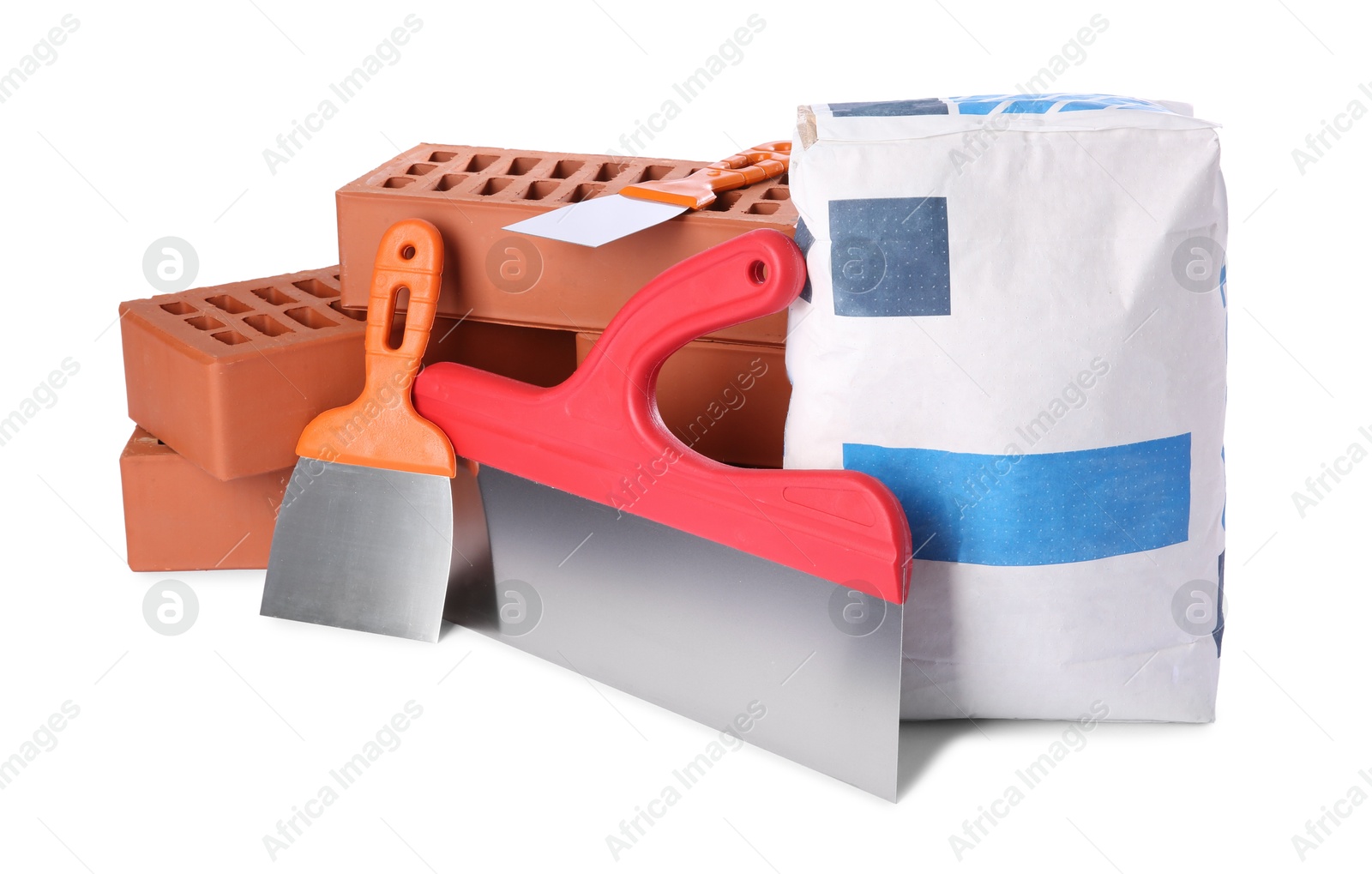 Photo of Cement powder in bag, red bricks and putty knives isolated on white. Building materials and construction tools