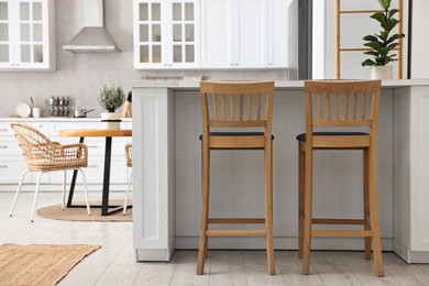 Photo of Stylish kitchen with bar stools. Interior design