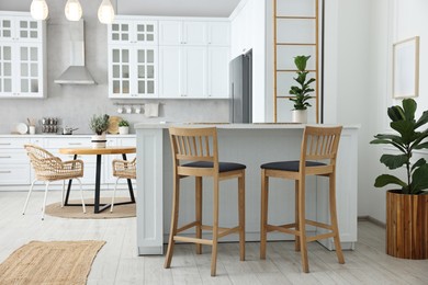 Photo of Stylish kitchen with bar stools. Interior design