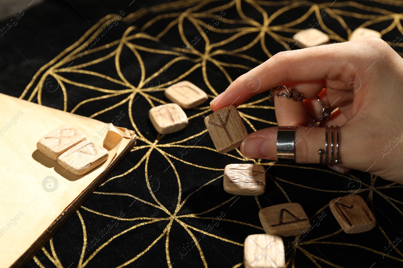 Photo of Woman with rune Algiz at divination mat, closeup