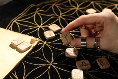 Photo of Woman with rune Algiz at divination mat, closeup