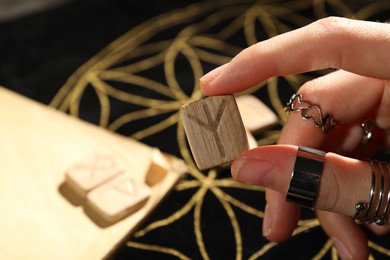 Photo of Woman with rune Algiz at divination mat, closeup