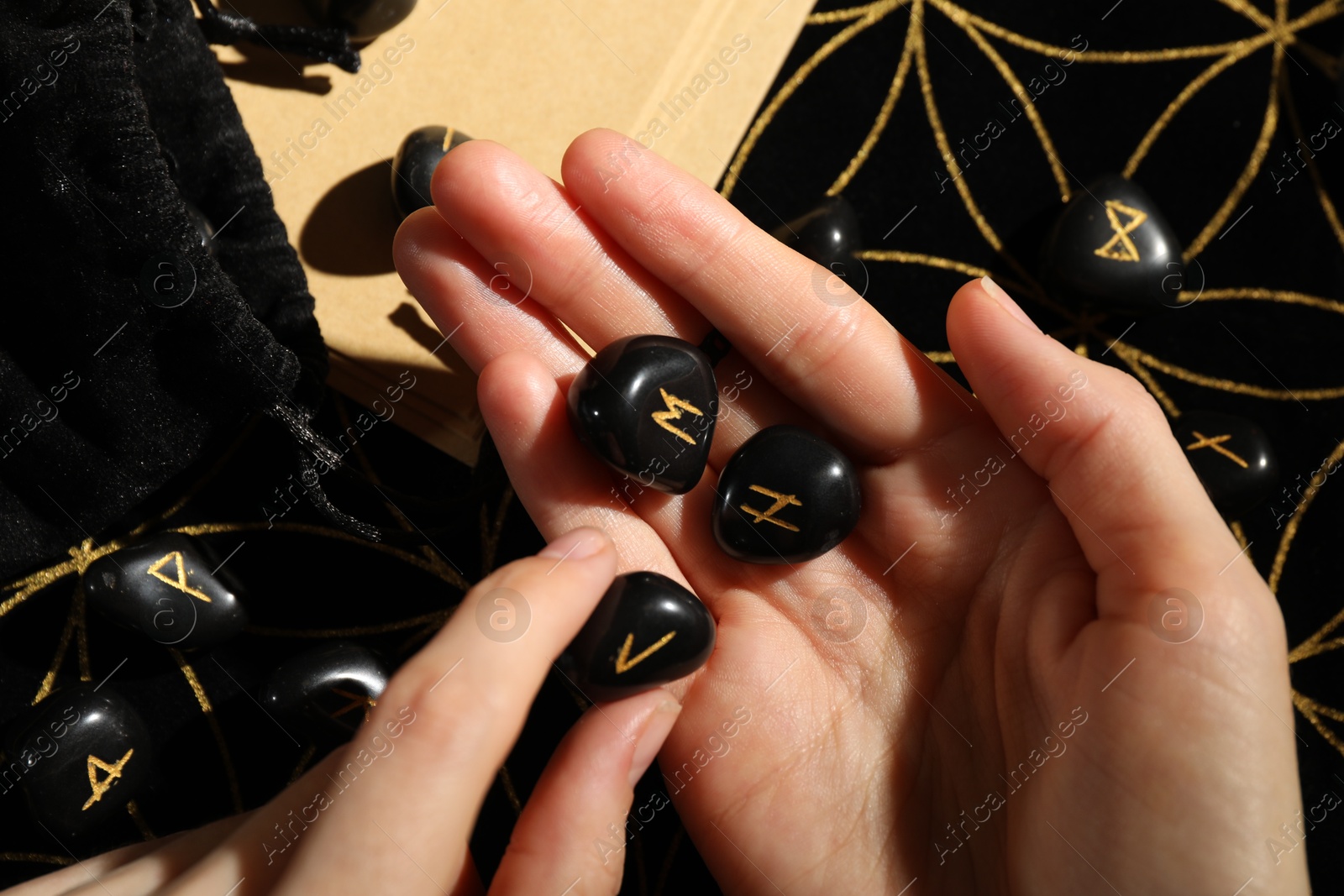 Photo of Woman with black runes at table, top view