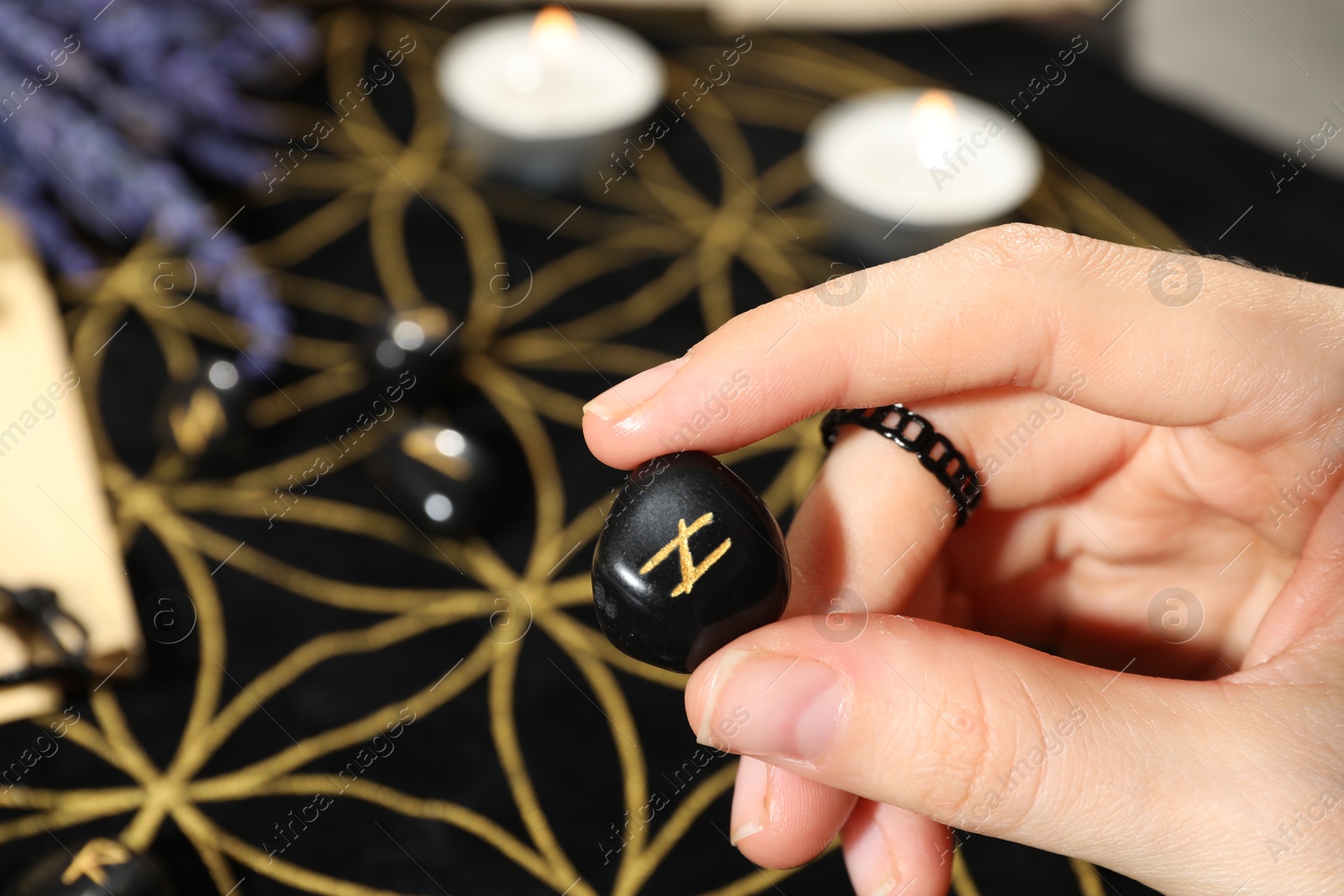 Photo of Woman with rune Hagalaz at table, closeup