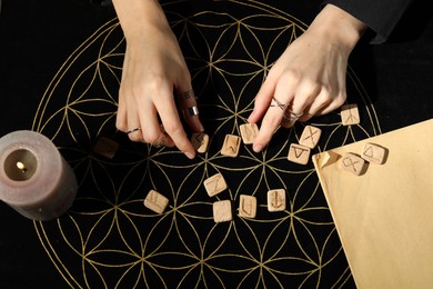 Photo of Woman with wooden runes at divination mat, top view