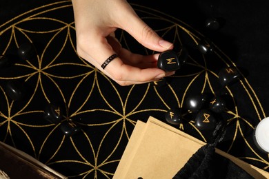 Photo of Woman with rune Ehwaz at divination mat, top view