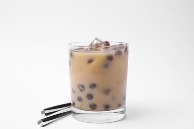 Photo of Tasty milk bubble tea in glass and straws on white background