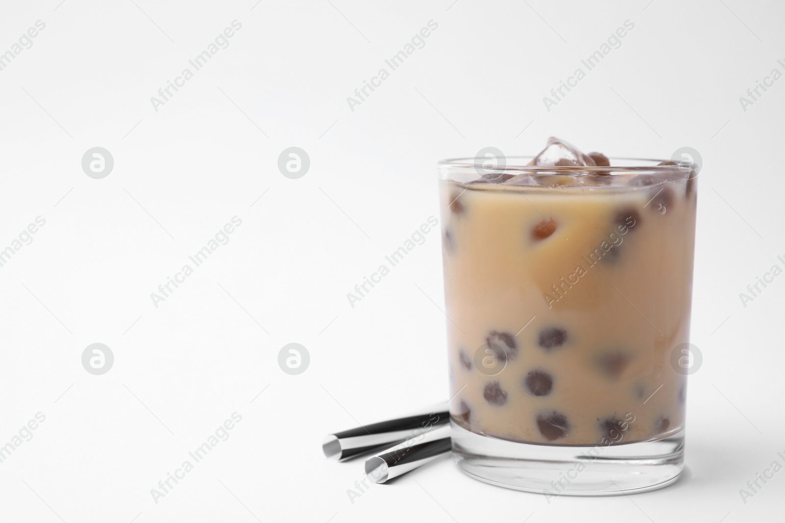 Photo of Tasty milk bubble tea in glass and straws on white background, space for text