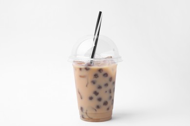 Photo of Tasty milk bubble tea in plastic cup on white background