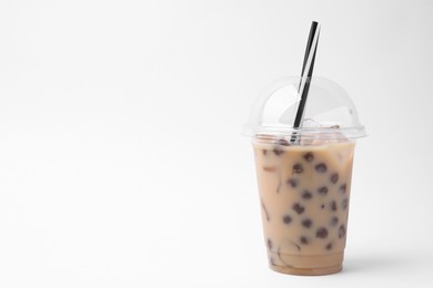 Photo of Tasty milk bubble tea in plastic cup on white background, space for text