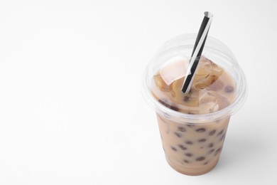 Photo of Tasty milk bubble tea in plastic cup on white background, closeup. Space for text