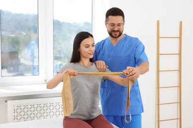 Photo of Physiotherapist working with patient in rehabilitation center